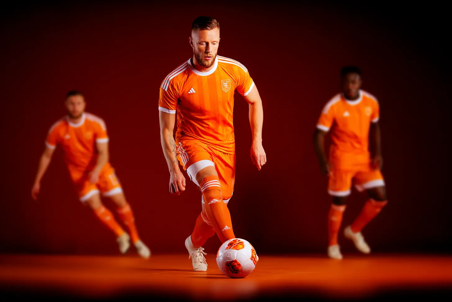 Jugador de fútbol con la camiseta naranja de BetWarrior conduciendo la pelota
